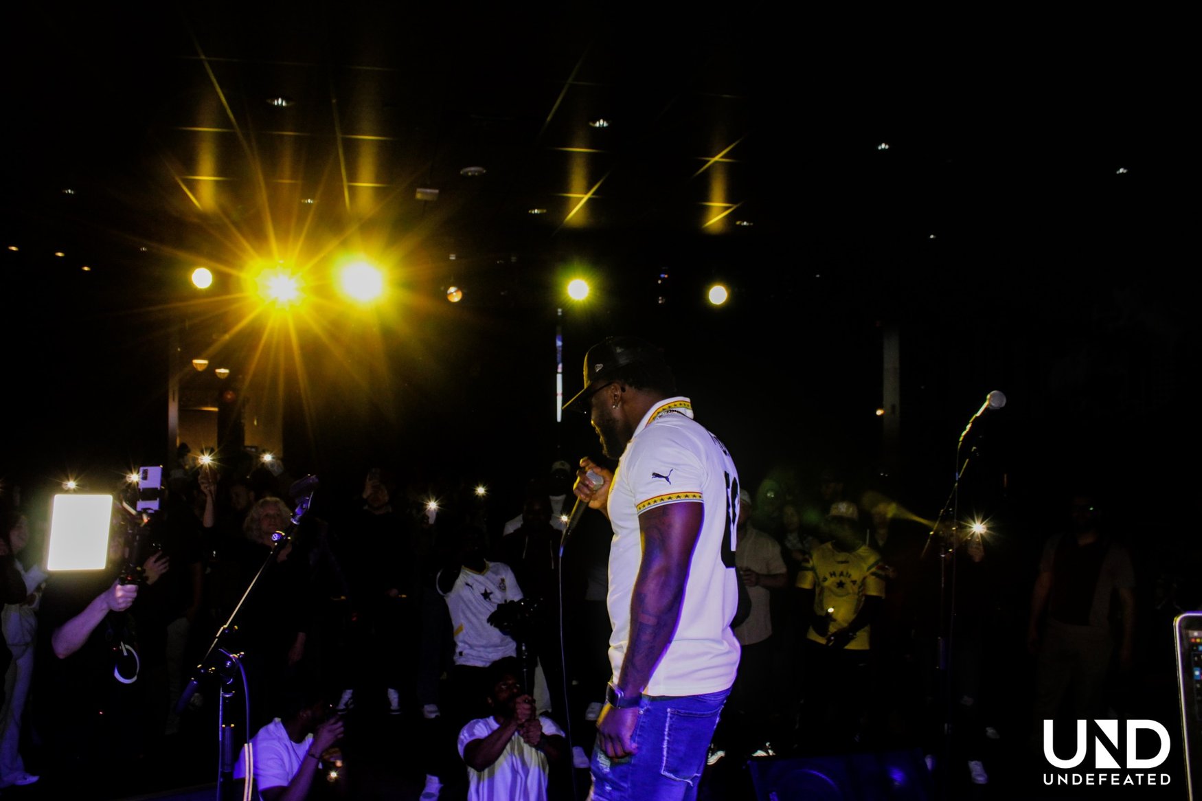 ELLI performing live in front of an audience with phone lights raised